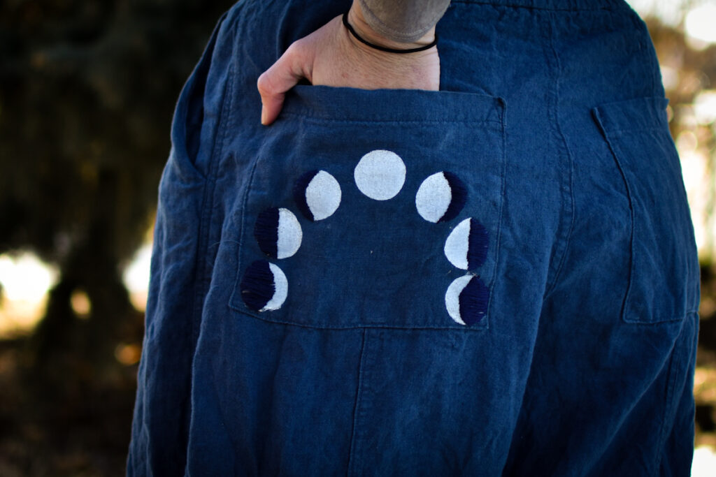 back pocket of linen pants with block printed moon cycles and embroidery