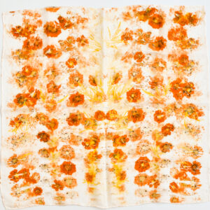 square silk scarf spread out flat with scattered images of orange flowers created with natural dye technique