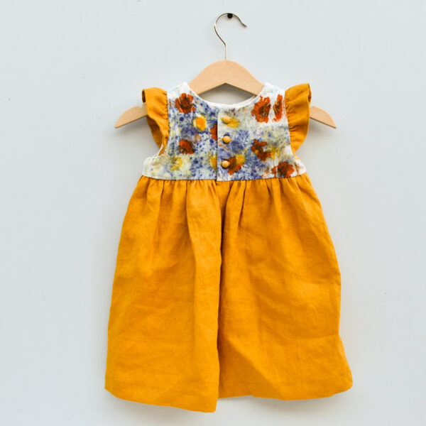 toddler dress with naturally dyed bodice using eco-printing technique with images of flowers on raw silk, golden gathered skirt and arm ruffles