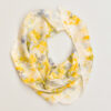 large silk square scarf draped into a circle with scattered yellow and purple, and petal images on white background. made with natural dye technique