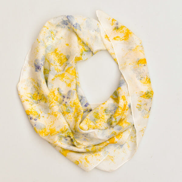large silk square scarf draped into a circle with scattered yellow and purple, and petal images on white background. made with natural dye technique