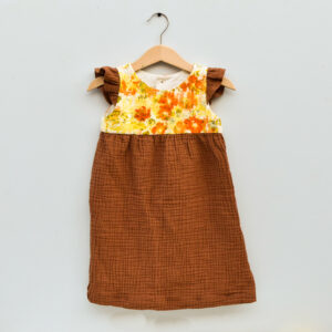 2T toddler dress, sleevless with ruffles, high waist, gathered skirt. bodice is naturally dyed with flowers showing images of sulfur cosmos and marigold petals. skirt and ruffles are brown double gauze cotton with checked texture