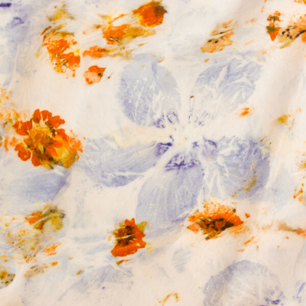 detail of silk scarf showing purple and orange flowers eco-printed onto silk with natural dye technique