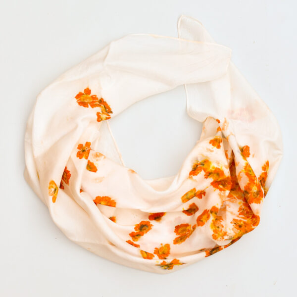 silk scarf draped into a circle, scattered images of orange coreopsis flowers on fabric