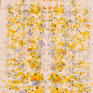 large silk square scarf with scattered yellow, purple, and hints of orange flower and petal images on white background. made with natural dye technique