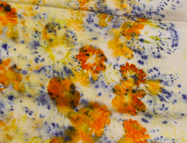detail of orange flowers and purple specked flowers scattered on white background