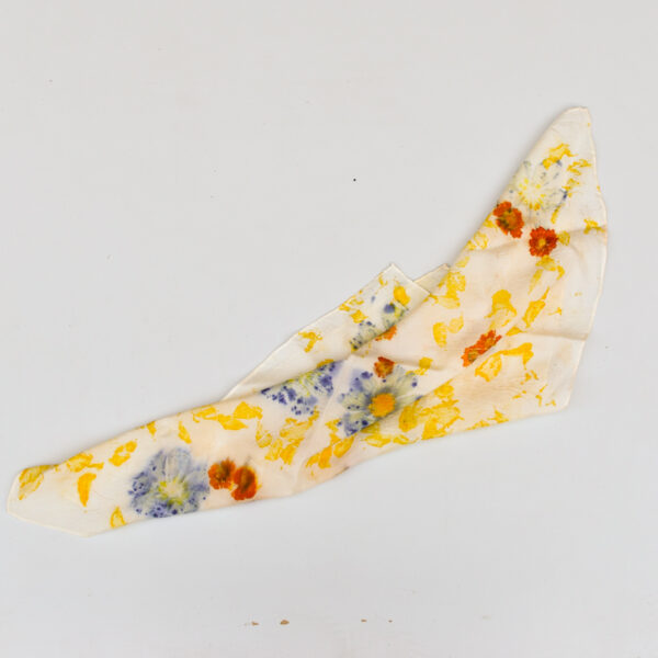 casually dropped silk scarf with purple, yellow, and orange flower and petal images