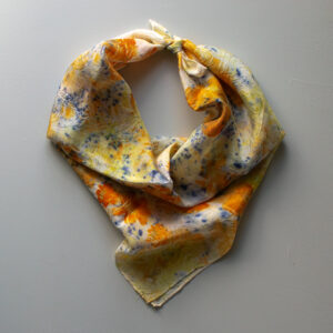 rumpled silk scarf with speckled purple and images of orange flowers on white background